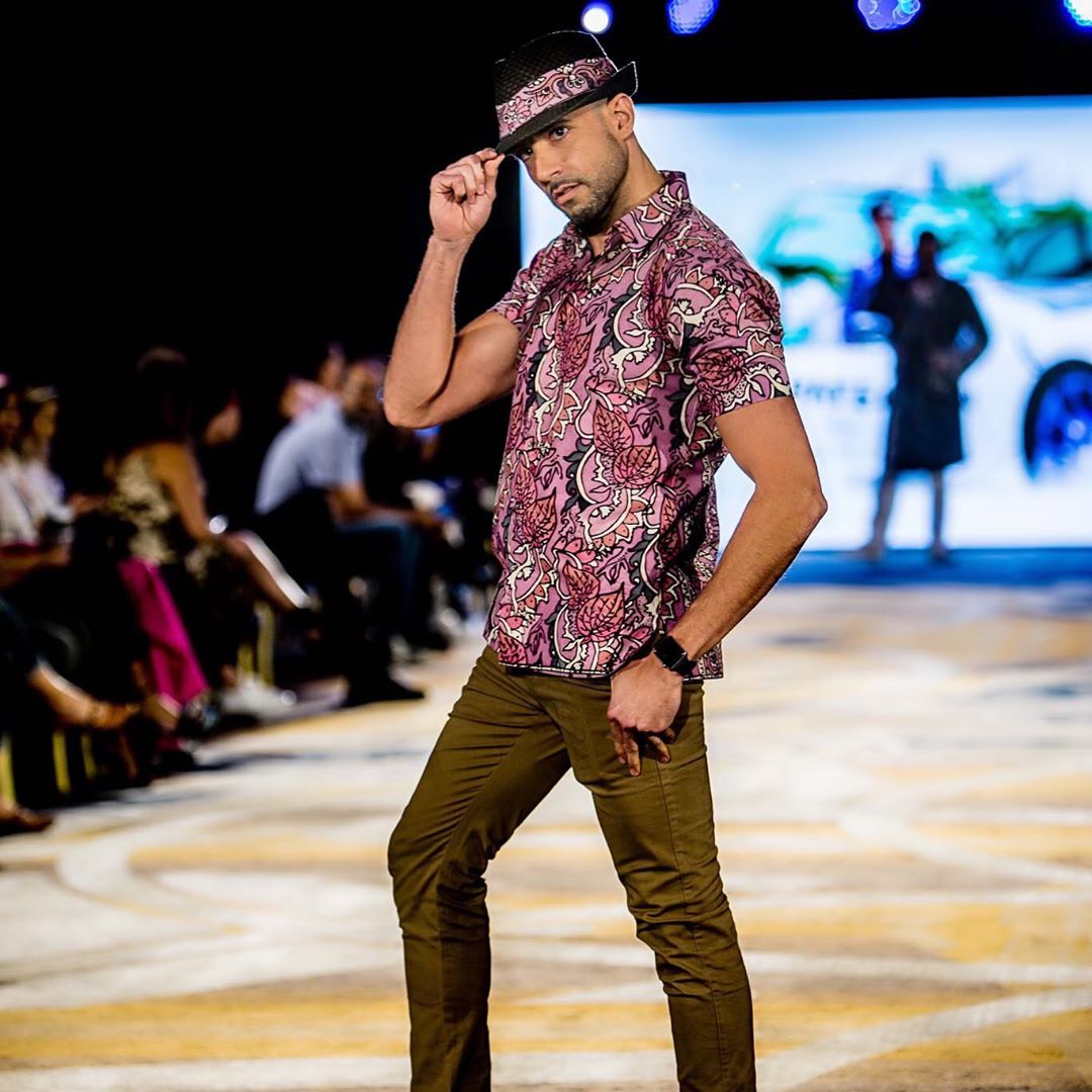 A man in a hat and shirt on the runway.