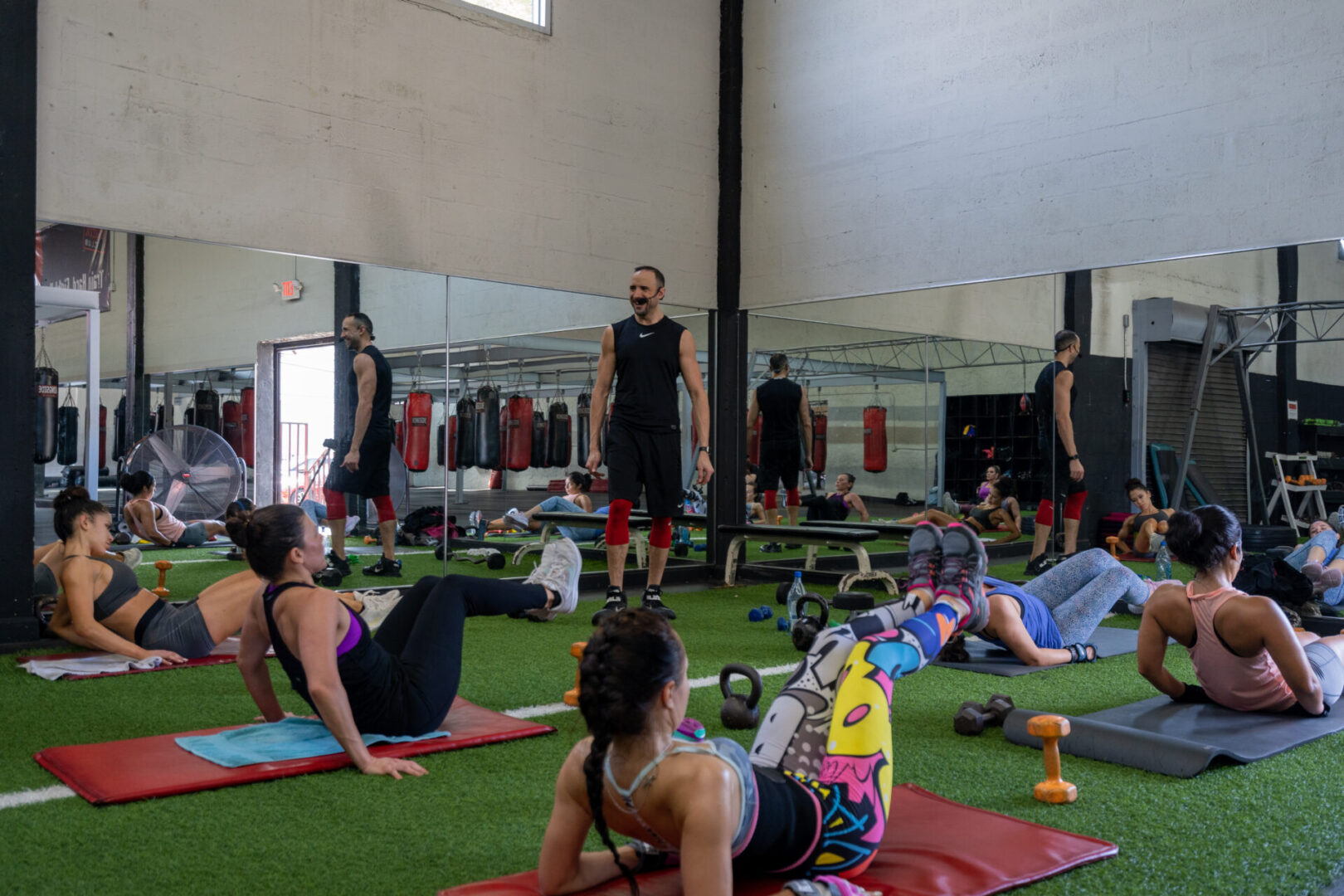 A group of people in the gym doing different exercises.